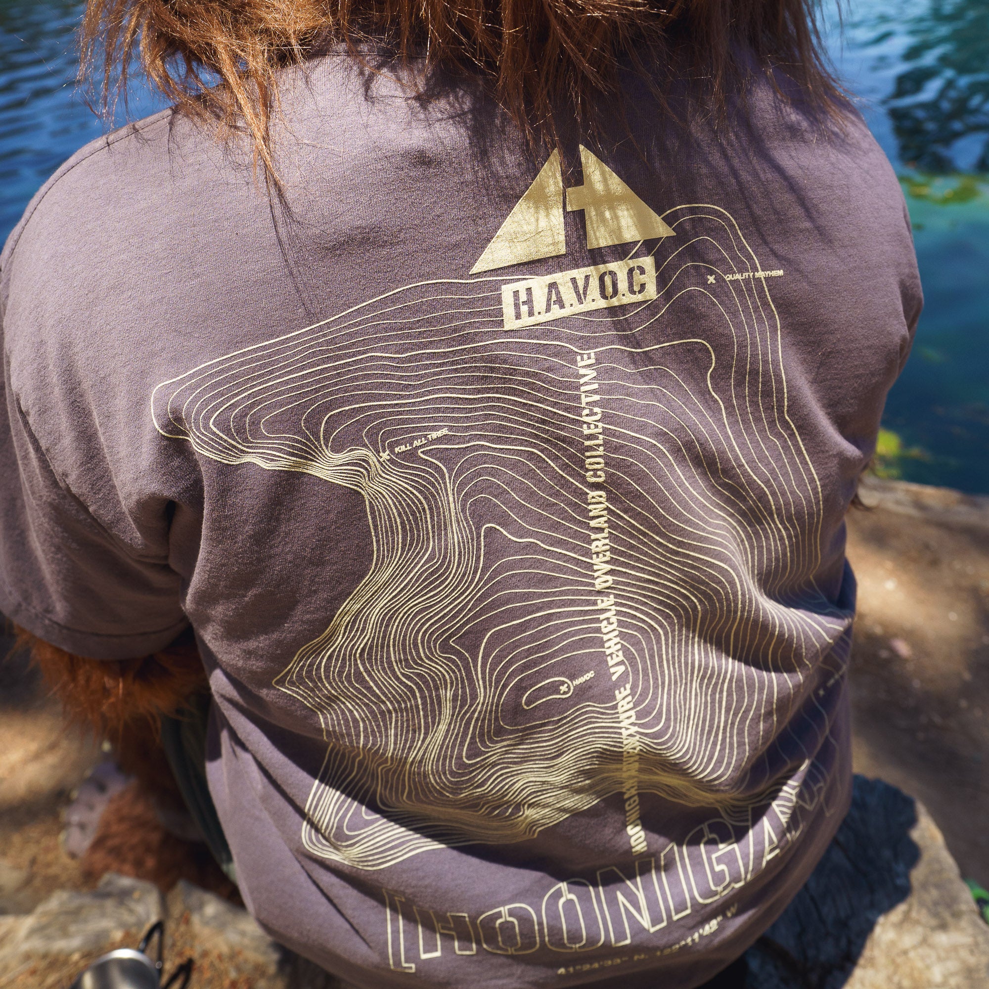 Back of a person wearing a gray Hoonigan TOPOGRAPHIC TERRAIN short sleeve tee with topographic map design and text.
