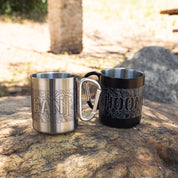 Hoonigan TOPOGRAPHIC CENSBOR BAR Carabiner Mug set with engraved topographic design, placed on a rock outdoors.