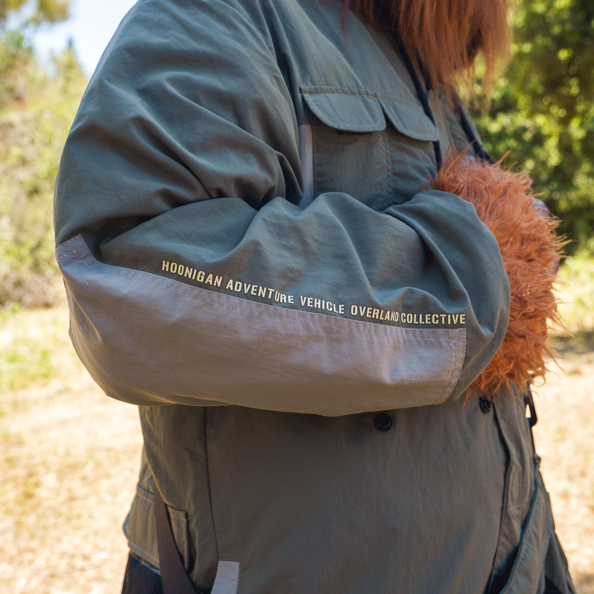 Rain-activated Hoonigan H.A.V.O.C. windbreaker jacket with text on sleeve, designed for outdoor adventure and weather protection.