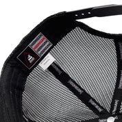 Close-up of the inside of a Hoonigan HITS V2 Trucker Hat showing mesh lining, branding tags, and fabric composition details.