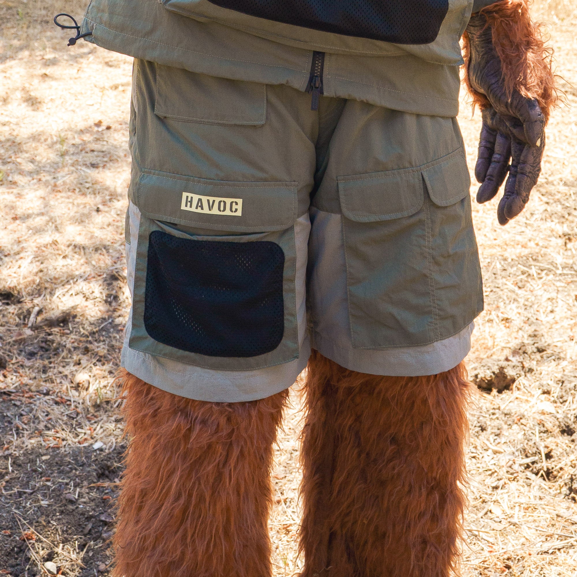 Rain-activated cargo shorts with multiple pockets, including a black mesh pocket and a "HAVOC" patch, worn by a furry creature outdoors.