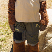 Close-up of Hoonigan H.A.V.O.C. rain-activated cargo shorts on a furry animal, featuring multiple pockets and branding details.