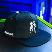Black snapback hat with white "HOONIGAN" text and graphic design, featuring a curved brim and adjustable strap.