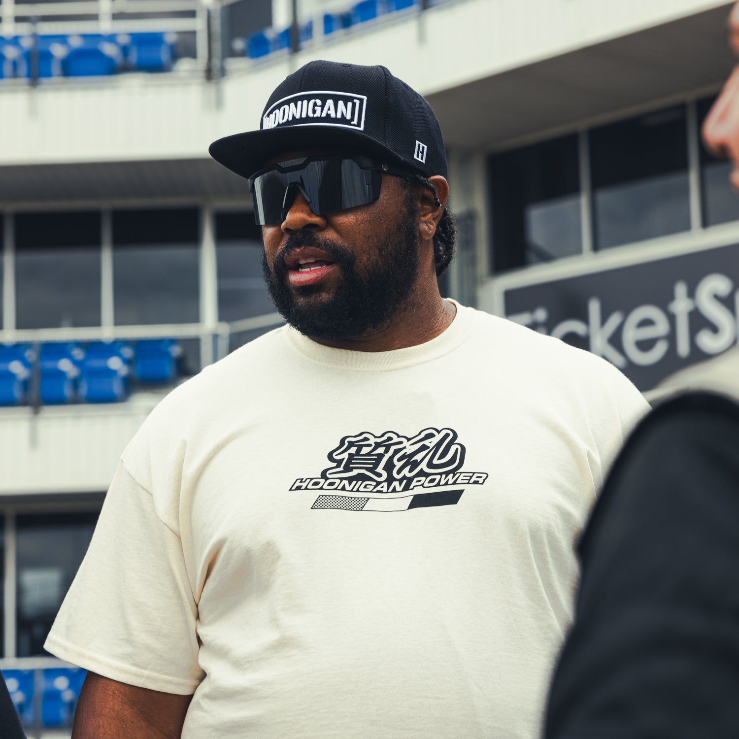 Hoonigan ON SITE Short Sleeve Tee featuring a black design with bold white graphics and a relaxed fit, displayed on a hanger.