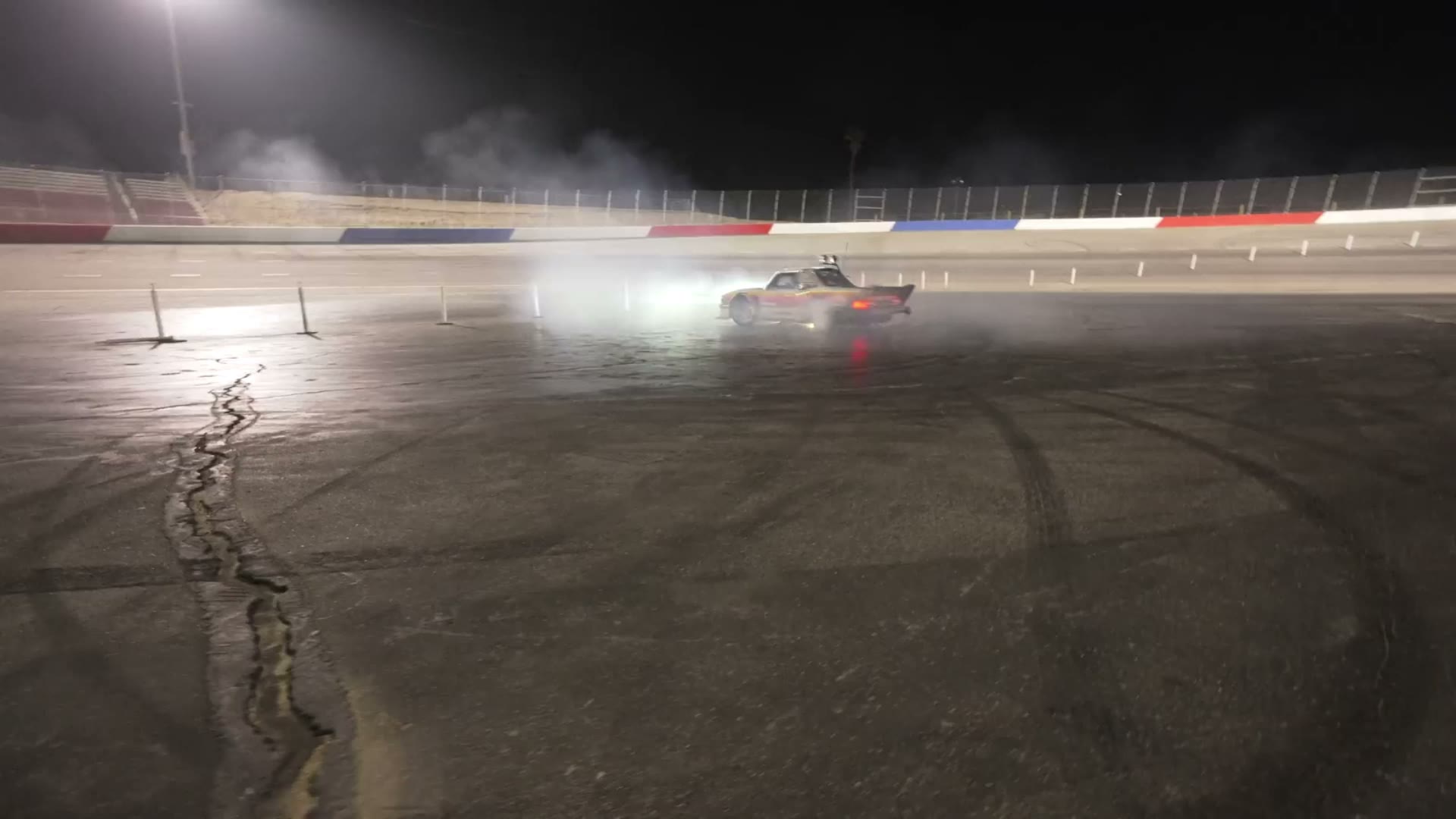 Car drifting through tire smoke on a night track