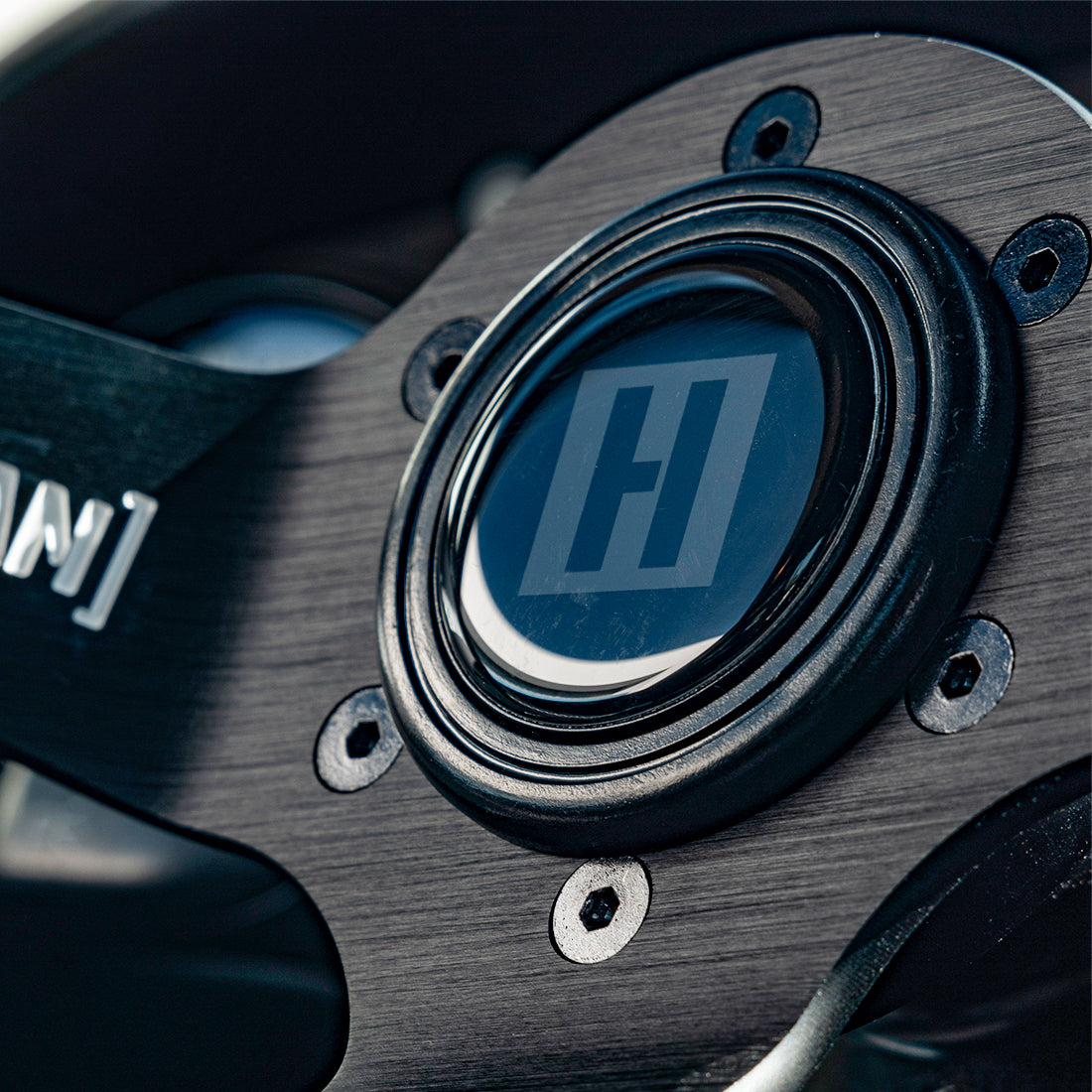 Hoonigan H BOX HORN button featuring a sleek design with the Hoonigan logo, ideal for motorsport enthusiasts and custom steering wheels.