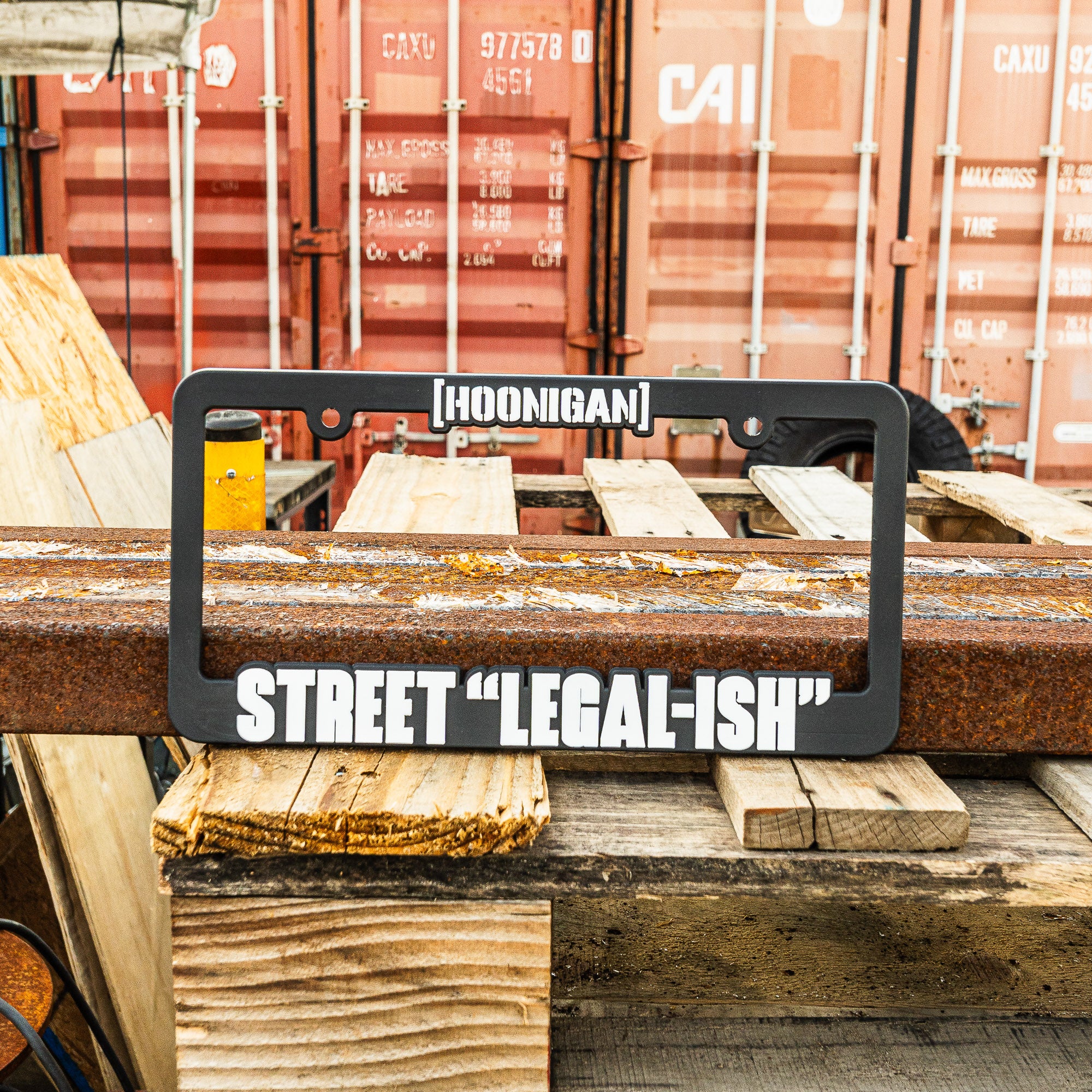 Hoonigan STREET LEGAL license plate frame featuring bold text on a rugged background, perfect for car enthusiasts.