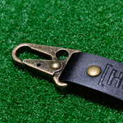 Hoonigan leather keychain featuring a sturdy clip and embossed logo, perfect for automotive enthusiasts.