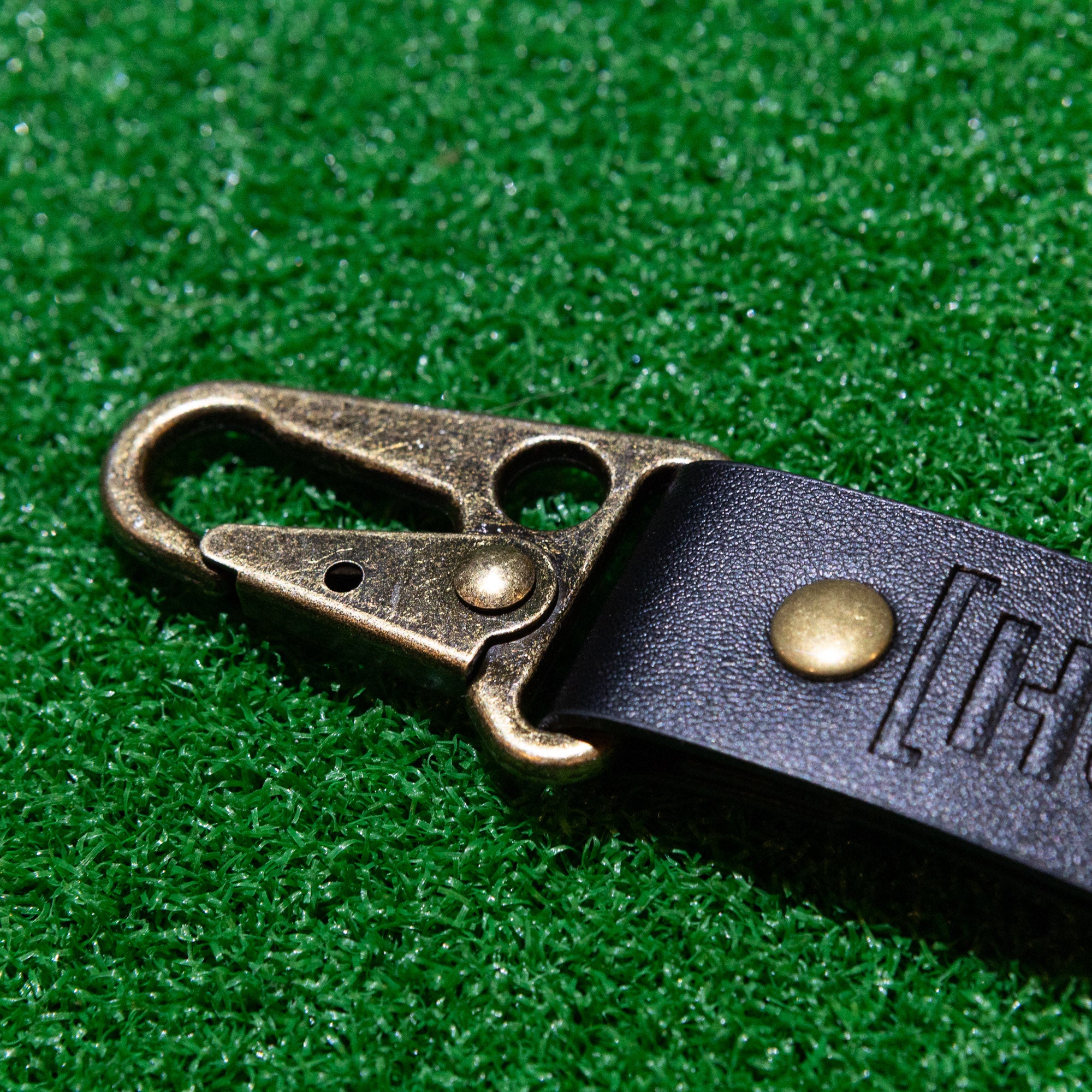 Hoonigan leather keychain featuring a sturdy clip and embossed logo, perfect for automotive enthusiasts.