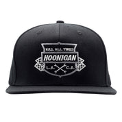 Black snapback hat featuring a prominent embroidered Hoonigan logo with the phrase "Kill All Tires" and crossed flags.