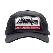 Black unstructured strapback hat featuring a Hoonigan logo patch with the text "MFG. QUALITY MAYHEM" for motorsport enthusiasts.