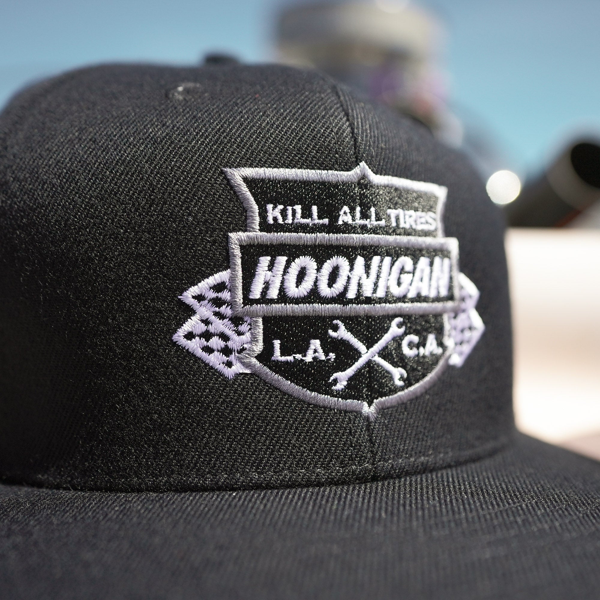 Black snapback hat featuring a bold embroidered Hoonigan logo with the phrase "Kill All Tires" and crossed wrenches.