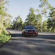 Hoonigan x Lia Block UR STAR Sweatpants displayed with a dynamic shot of a classic Audi driving on a winding road.