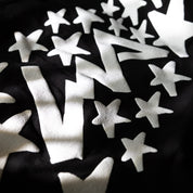 Close-up of the Hoonigan x Lia Block UR STAR Short Sleeve T-Shirt featuring bold white star graphics on a black background.