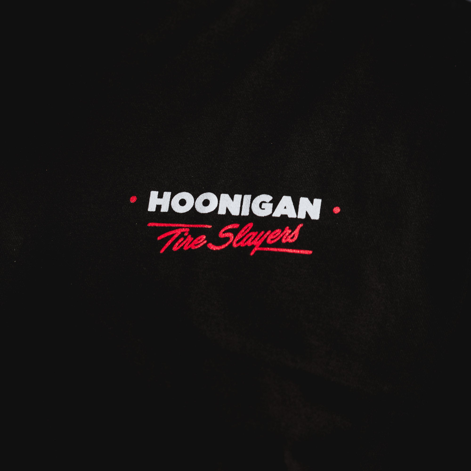 Black short sleeve t-shirt featuring "Hoonigan" and "Tire Slayers" embroidered in bold red and white text.
