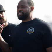 Man wearing a black Hoonigan GYMKHANA AUSSIE SHRED HKR short sleeve t-shirt, showcasing automotive lifestyle and culture.