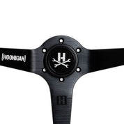 Limited edition Hoonigan steering wheel featuring a sleek black design and logo, perfect for motorsport enthusiasts.