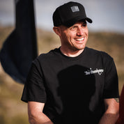 Hoonigan Motorsports snapback hat featuring a black base with a bold white logo on the front.