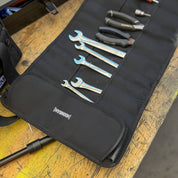 Hoonigan LIL TOOL ROLL displayed on a wooden surface, featuring various tools neatly organized in pockets.