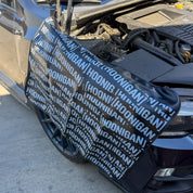 Hoonigan SCATTER PRINT Fender Cover draped over a car engine, featuring a bold black and white design.