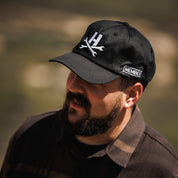 Hoonigan MAYHEM Unstructured Strapback Hat, black with white logo and adjustable strap.
