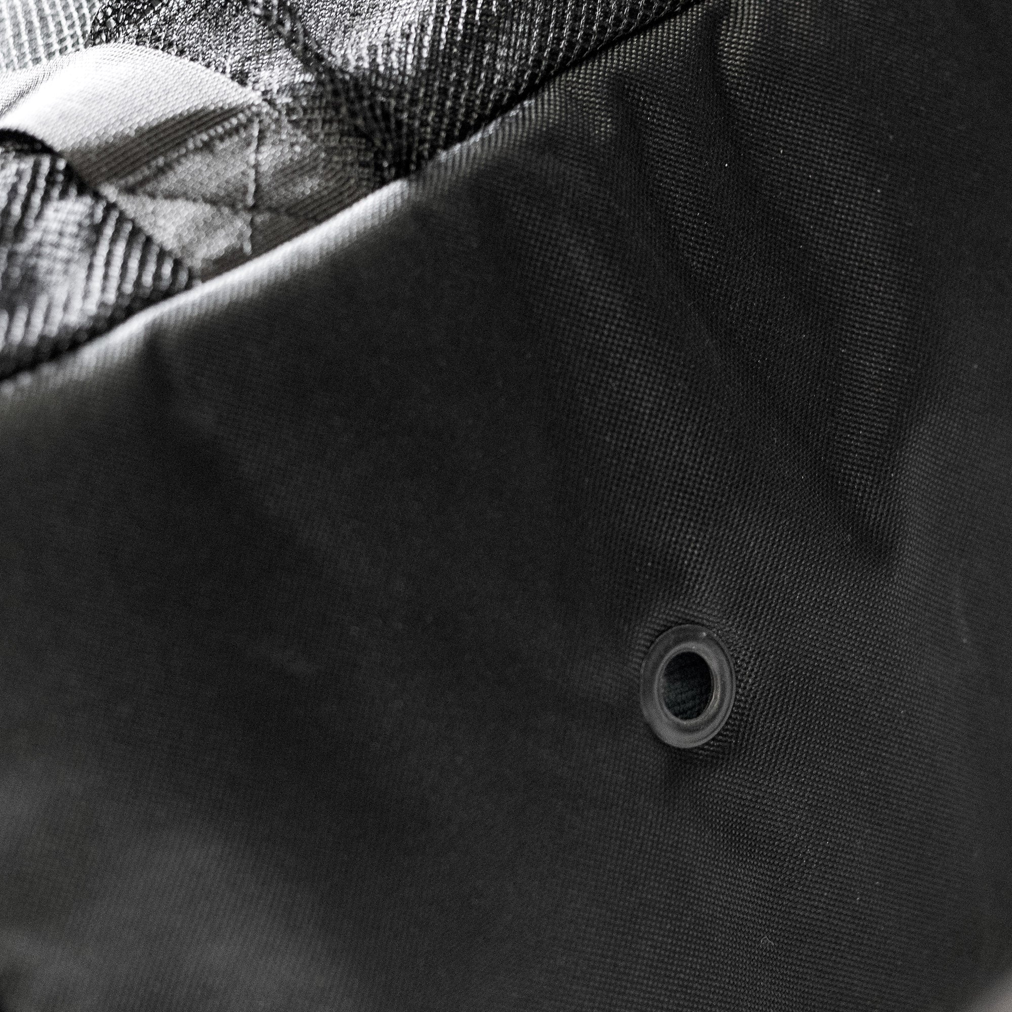 Close-up of the Hoonigan CENSOR BAR Spare Tire Tailgate Backpack showcasing durable fabric and reinforced grommet detail.