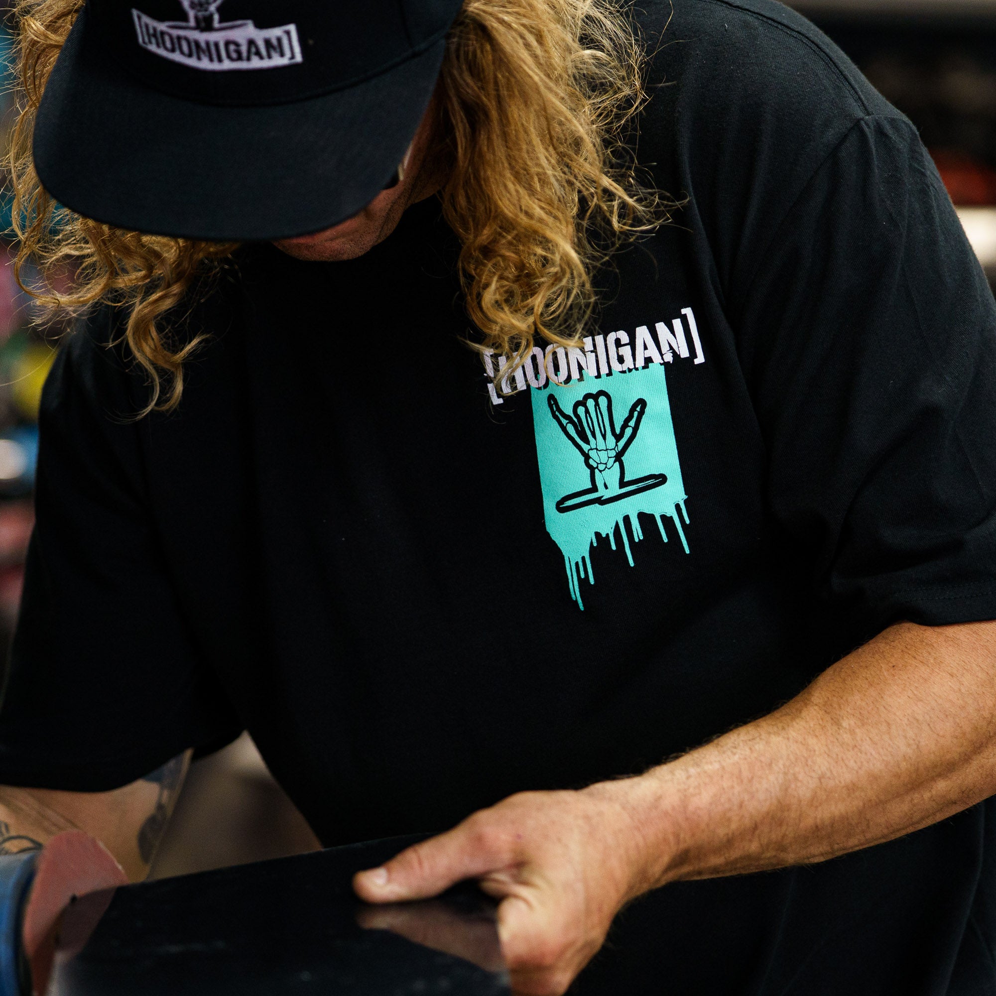 Black short sleeve t-shirt featuring Hoonigan x Shreddy design with a hand graphic and dripping paint detail.