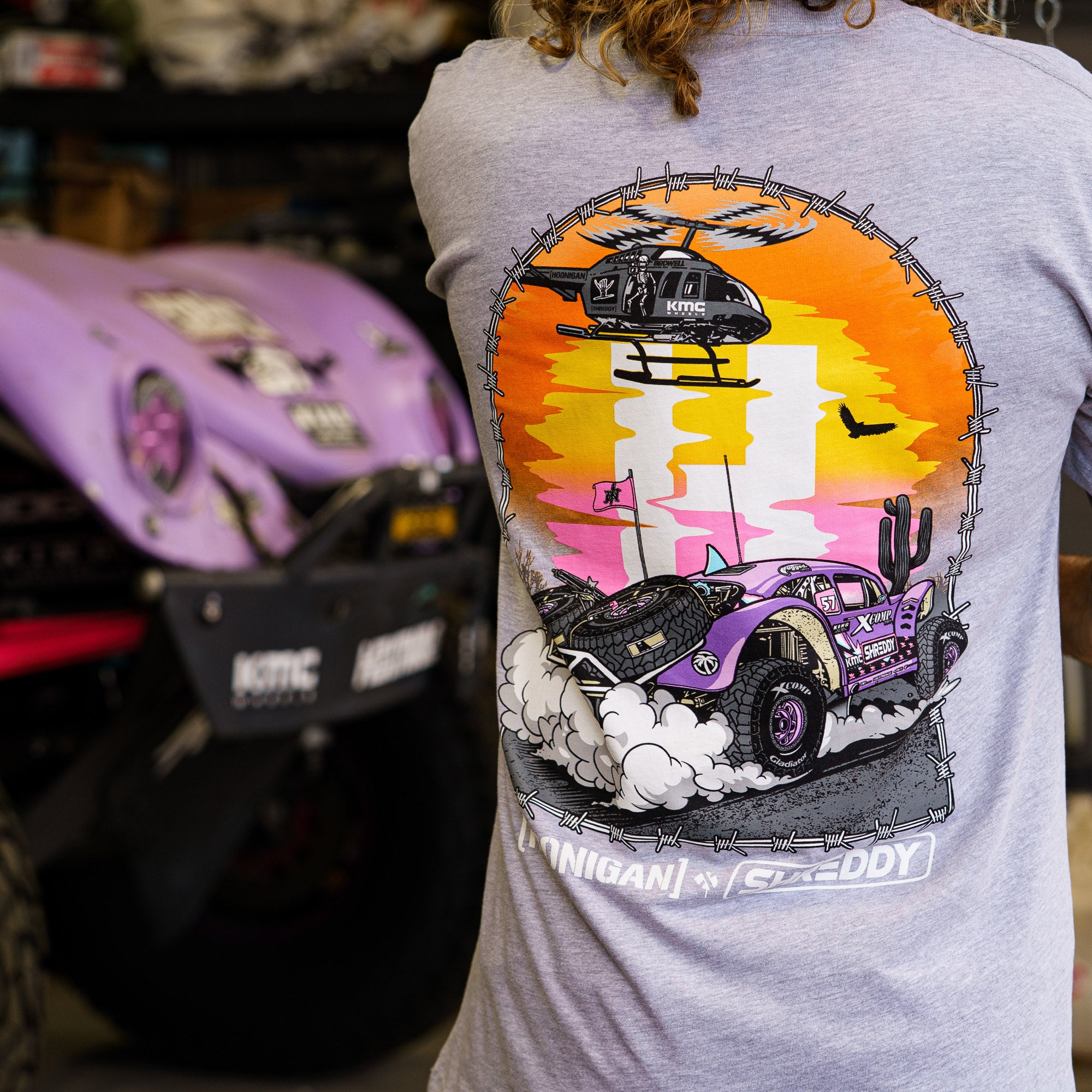 Hoonigan x Shreddy Desert Shred T-shirt featuring a vibrant graphic of a desert scene with a vehicle and helicopter.