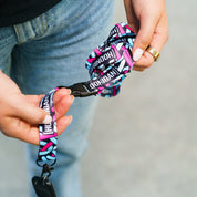 Colorful Hoonigan x Lia Block SCRIPT lanyard held by a person, featuring bold branding and a secure clip for keys or ID.