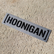 Hoonigan BEAMS CENSOR BAR sticker on a textured surface, showcasing bold black lettering on a silver background.