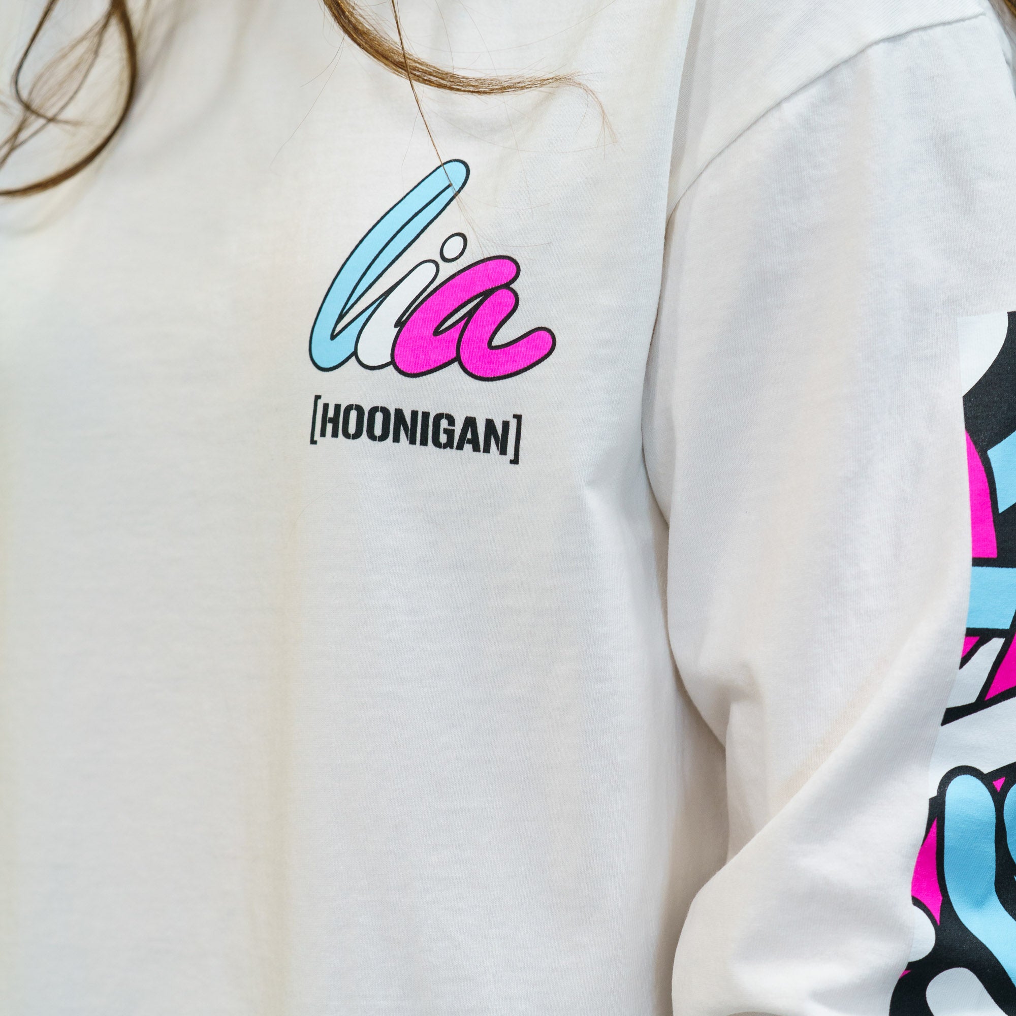 Long sleeve white t-shirt featuring colorful Hoonigan x Lia Block graphics on the chest and sleeve.