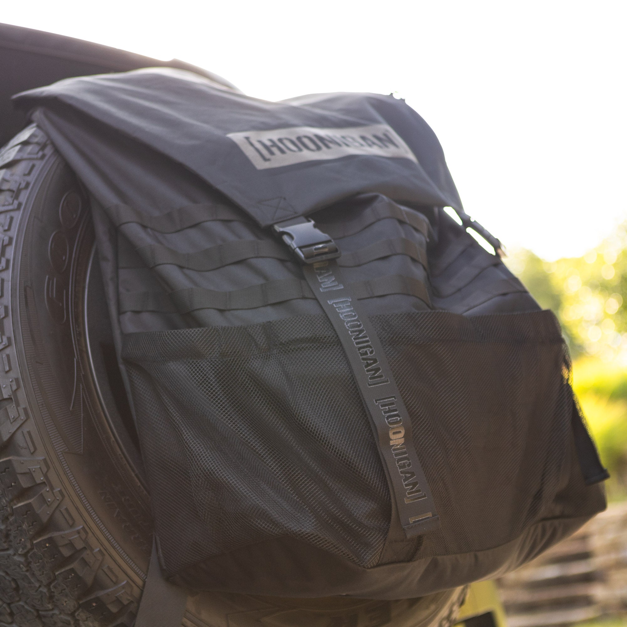 Hoonigan CENSOR BAR spare tire backpack featuring durable fabric and multiple storage compartments for automotive enthusiasts.