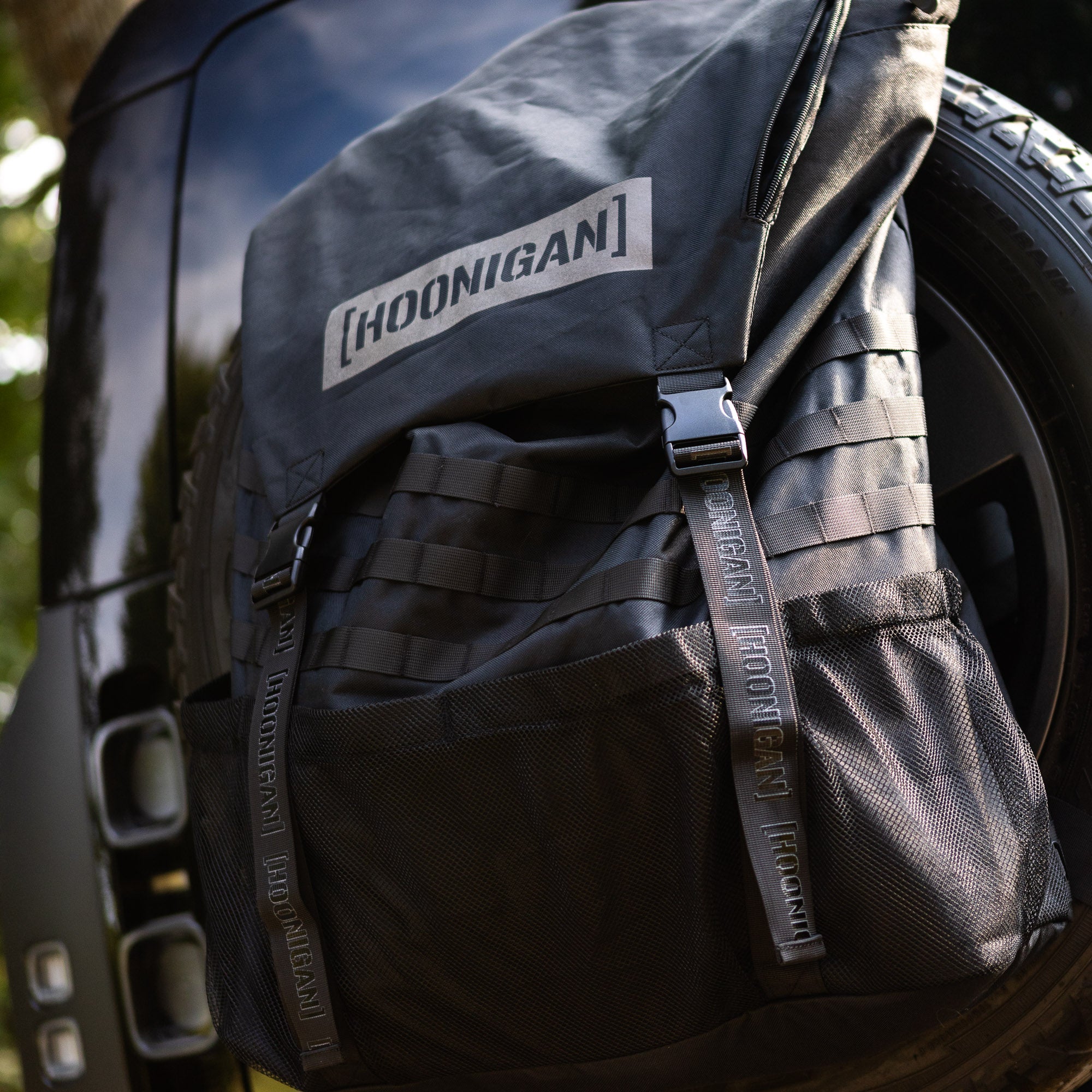 Hoonigan CENSOR BAR spare tire backpack designed for automotive enthusiasts, featuring durable straps and a sleek black design.