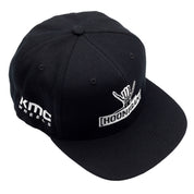 Black snapback hat featuring Hoonigan logo and KMC Wheels branding, perfect for motorsport enthusiasts.