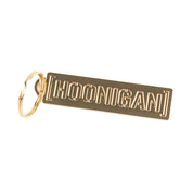 Gold metal keychain featuring the Hoonigan logo, perfect for automotive enthusiasts and car culture fans.