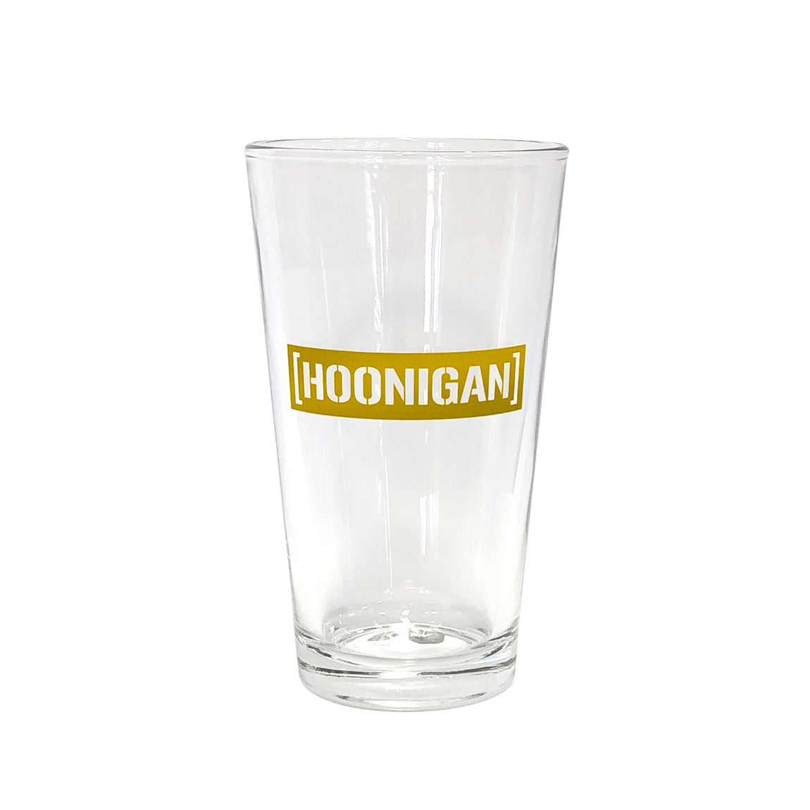 Clear pint glass featuring a bold gold Hoonigan logo, perfect for enjoying beverages while celebrating car culture.