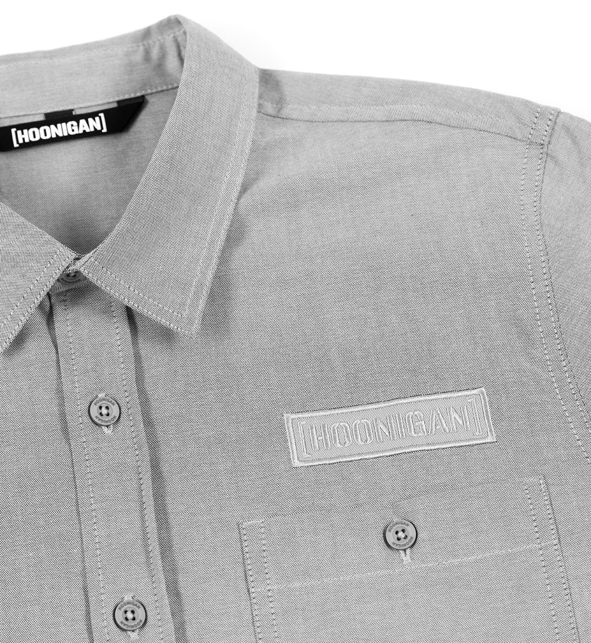 Hoonigan DONUT GARAGE Woven Long Sleeve Button-up Shirt in gray with a classic collar and logo detail.