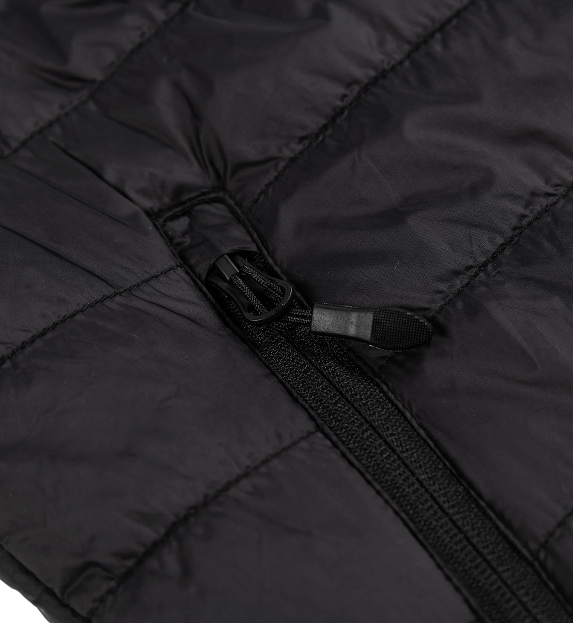 Close-up of a black GRILLE puffer vest showing a durable zipper and quilted, insulated fabric for warmth and style.