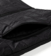 Close-up of a black GRILLE puffer vest with a zipper pocket, showcasing quilted, shiny, lightweight, insulated material.
